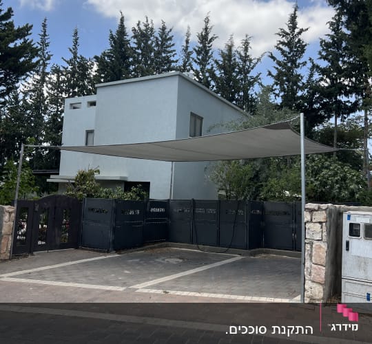 סוכך מתוח מעל חניה ליד בית פרטי